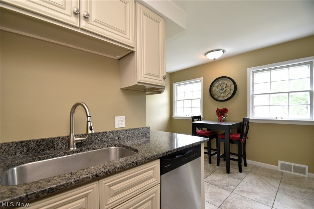 23901 Hazelmere Road Shaker Heights, OH 44122 - Photo 14 of 35 Kitchen featuring plenty of natural light, dark stone countertops, dishwasher, and light tile floors