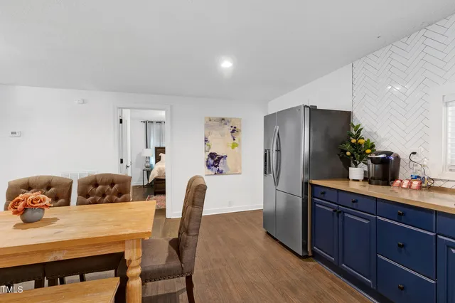 a kitchen with a table chairs refrigerator and cabinets