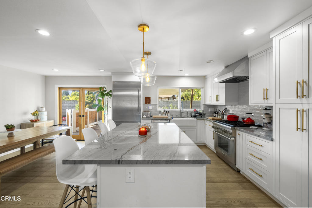 527 Keyser Rondo Camarillo, CA 93010 - Photo 15 of 42 a kitchen view with stainless steel appliances granite countertop a sink dishwasher a stove and white cabinets with wooden floor