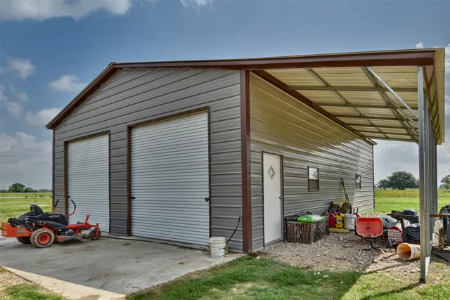 a backyard of a house with cars parked and a fire pit