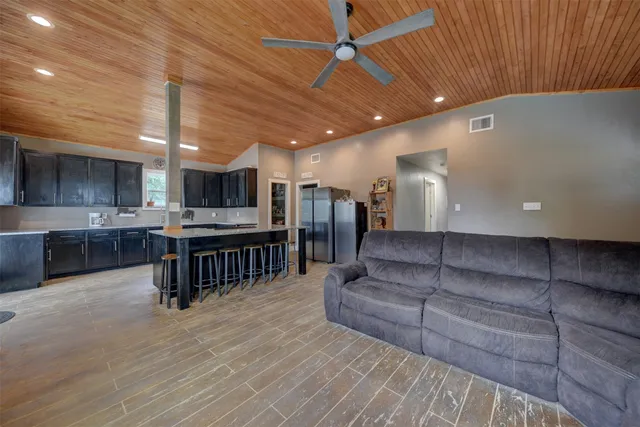 a living room with stainless steel appliances kitchen island granite countertop furniture and a kitchen view