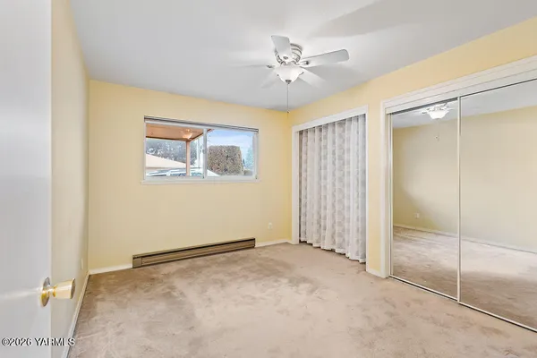 a view of an empty room with chandelier fan