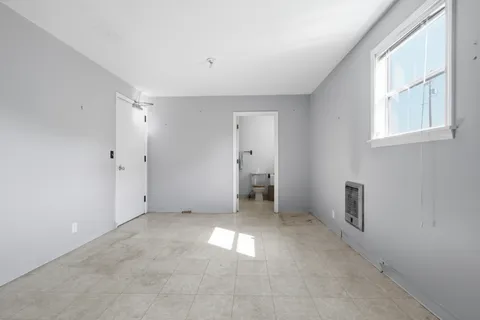 an empty room with windows and closet