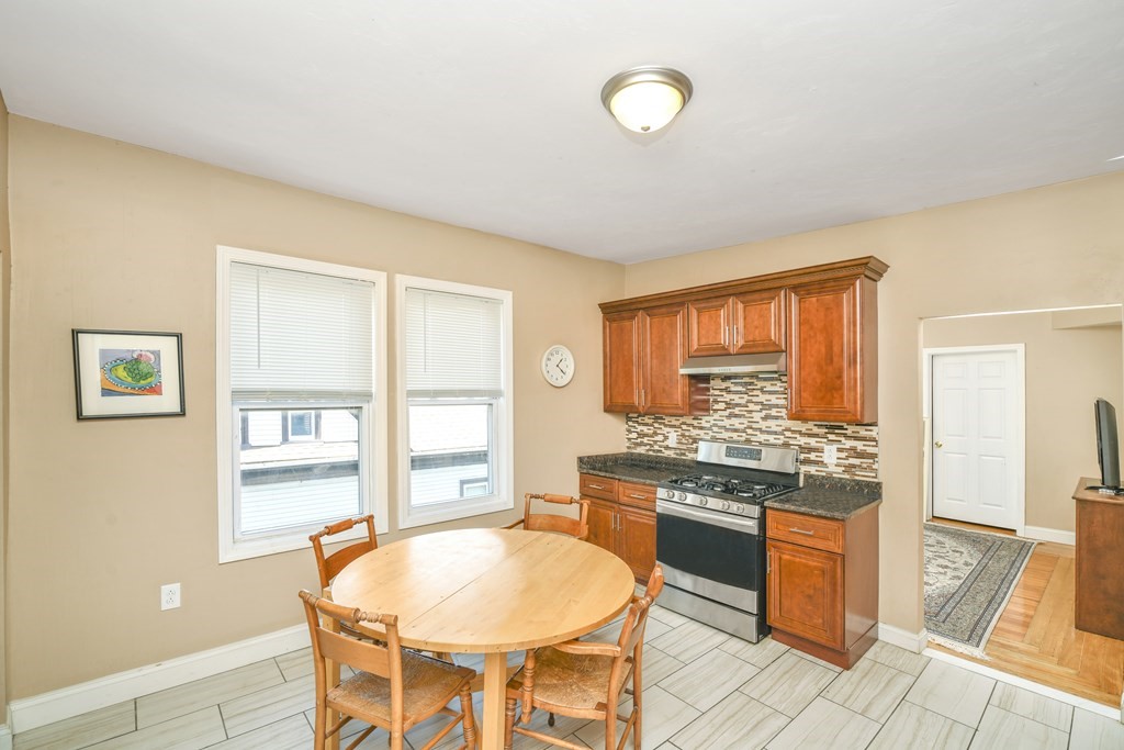 a kitchen with a stove a refrigerator and a dining table