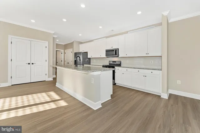 a kitchen with stainless steel appliances a sink a stove a refrigerator and cabinets