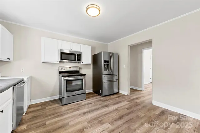a kitchen with granite countertop a refrigerator and a stove top oven