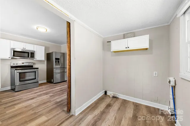 a view of a kitchen with wooden floor and electronic appliances
