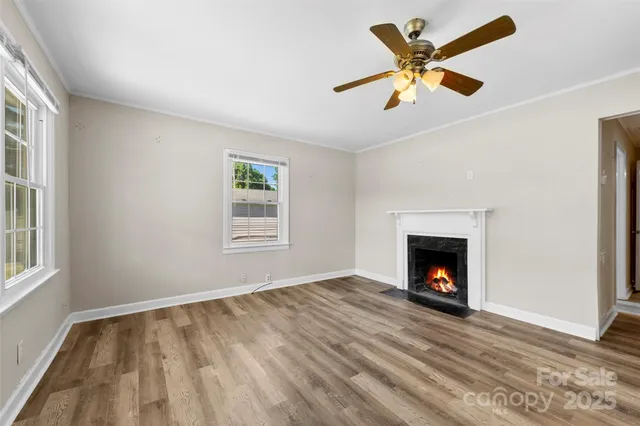 a view of an empty room with window and fire place