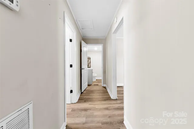 a view of a hallway with wooden floor and staircase