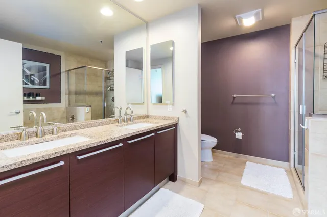 a bathroom with a granite countertop sink toilet and shower