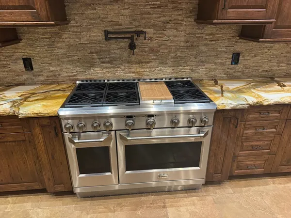 a stove top oven sitting inside of a kitchen