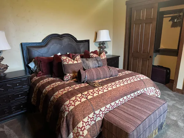 a bedroom with a bed and a lamp on dresser