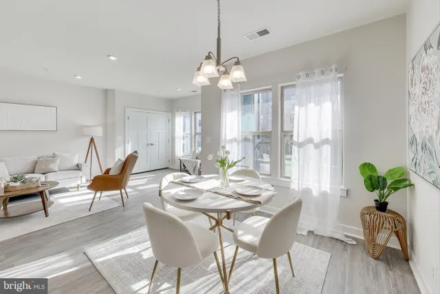 a living room with furniture wooden floor and a kitchen view