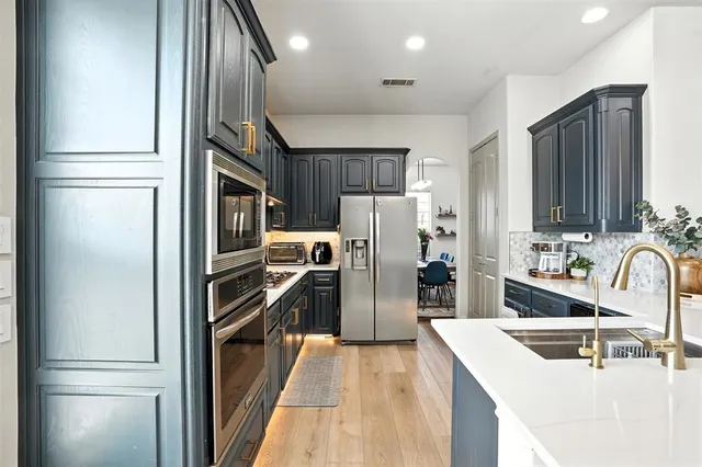 a kitchen with refrigerator a sink and cabinets