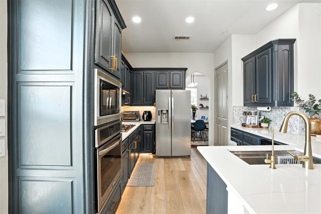 200 Thistle Ridge Denton, TX 76210 - Photo 11 of 31 a kitchen with refrigerator a sink and cabinets