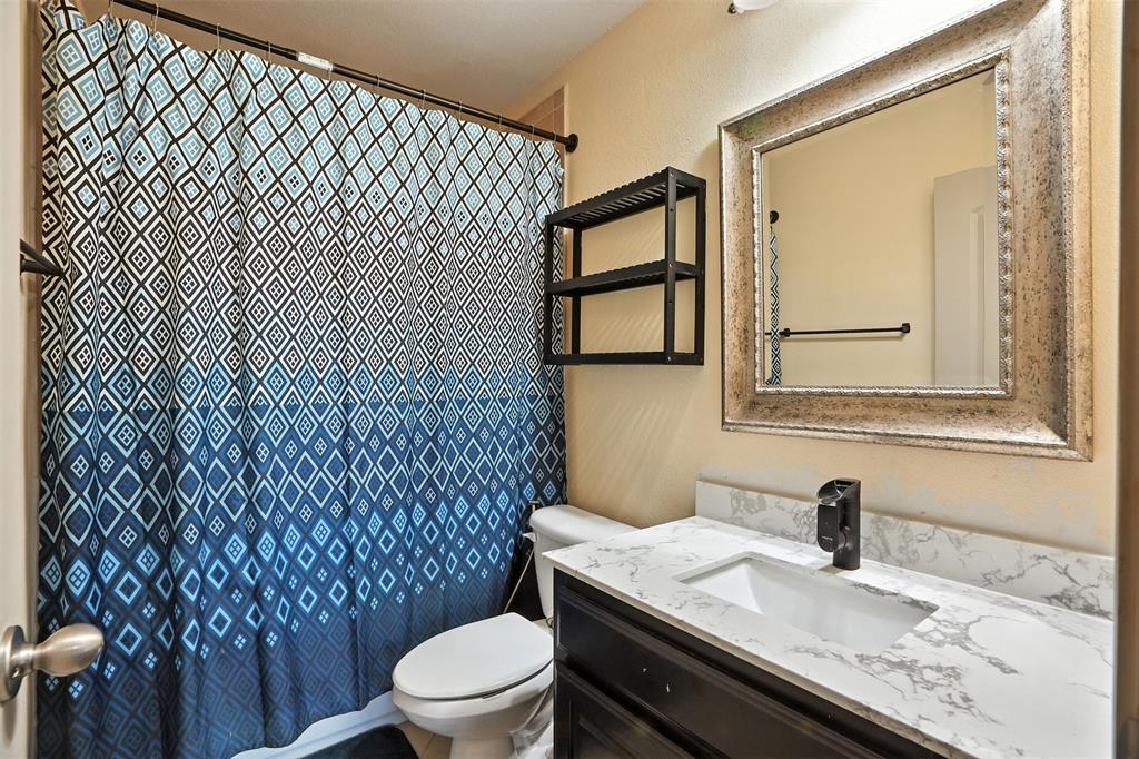 200 Thistle Ridge Denton, TX 76210 - Photo 27 of 31 a bathroom with a granite countertop toilet sink and mirror
