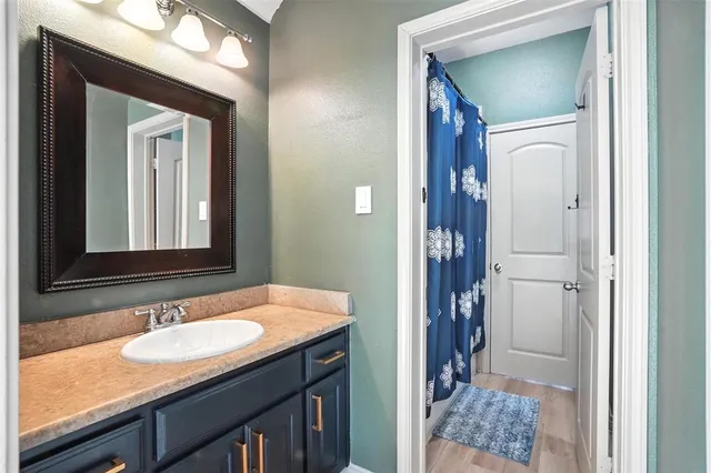 a bathroom with a granite countertop sink and a mirror