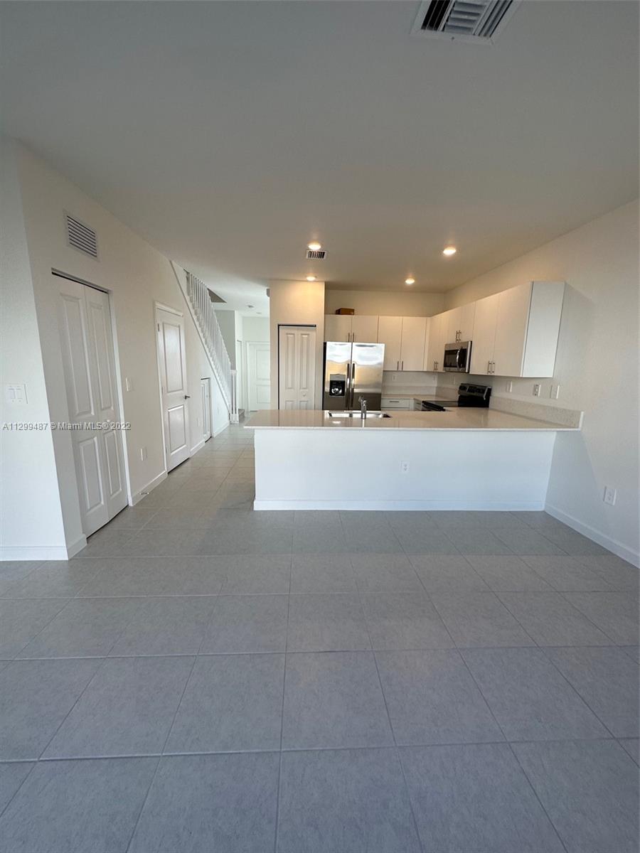 11863 Southwest 247th Terrace, Unit 11863 Homestead, FL 33032 - Photo 4 of 10 a view of a kitchen with a sink and a refrigerator