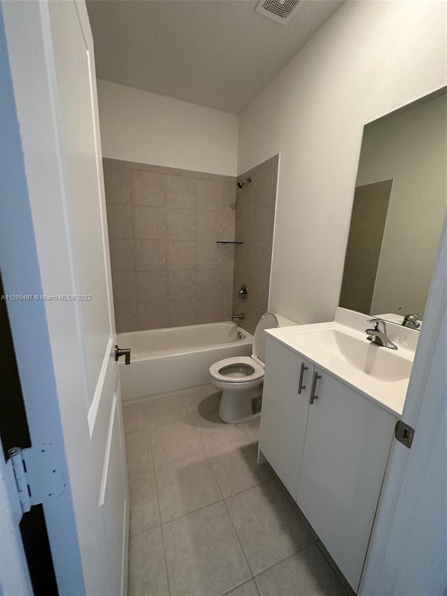 11863 Southwest 247th Terrace, Unit 11863 Homestead, FL 33032 - Photo 9 of 10 a bathroom with a sink a toilet and shower