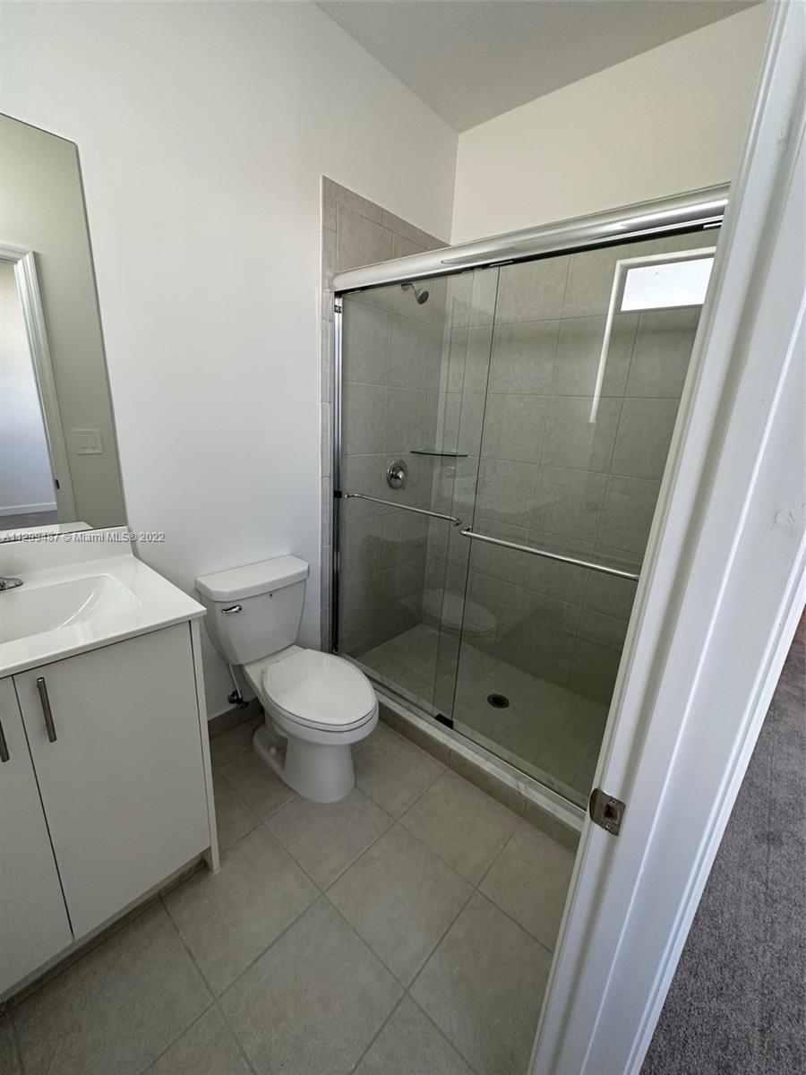 11863 Southwest 247th Terrace, Unit 11863 Homestead, FL 33032 - Photo 10 of 10 a bathroom with a shower toilet and sink