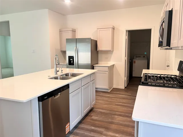 a kitchen with stainless steel appliances a sink and a refrigerator