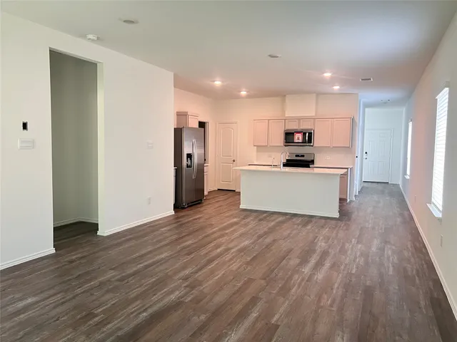 a view of kitchen with wooden floor and electronic appliances
