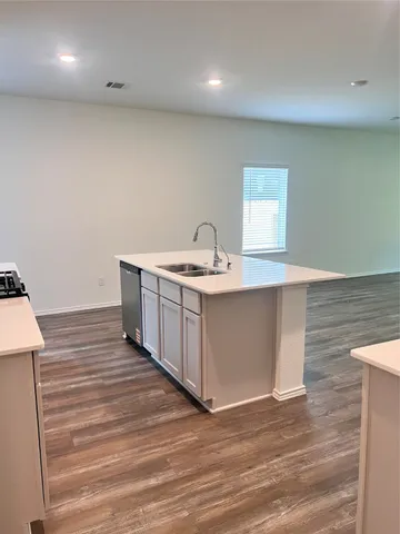 a room with a sink cabinets and wooden floor