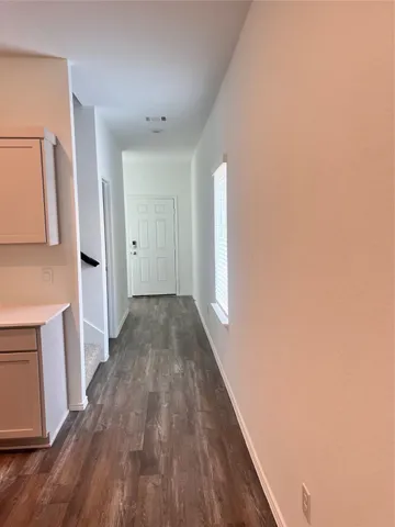 a view of a hallway with wooden floor and staircase
