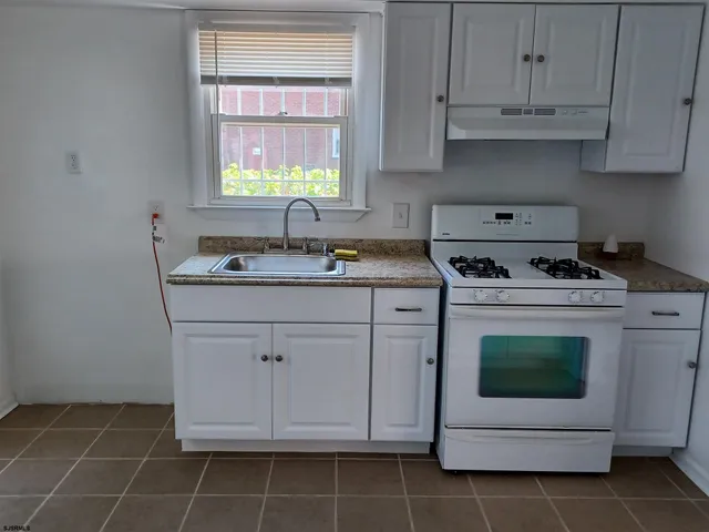 a kitchen with cabinets appliances a sink and a window