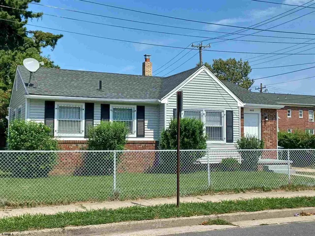 a view of a house with a small yard plants and large tree
