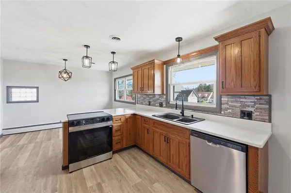 a kitchen with stainless steel appliances granite countertop a refrigerator a stove and a wooden floors