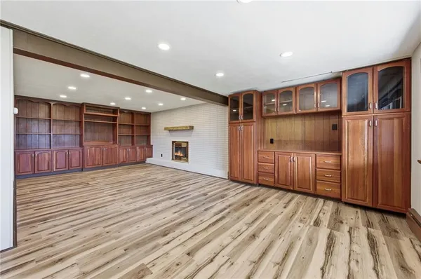 a view of empty room with wooden floor and fireplace