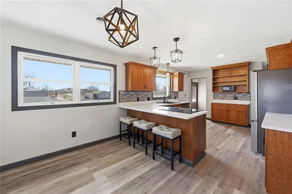 a kitchen with stainless steel appliances granite countertop a stove a sink dishwasher and a refrigerator with wooden cabinets