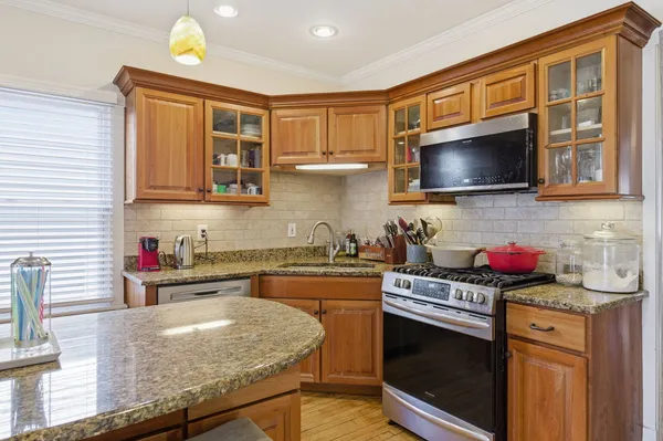 a kitchen with stainless steel appliances granite countertop a stove and cabinets