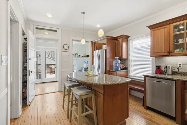 a dining hall with stainless steel appliances granite countertop a sink and wooden floor