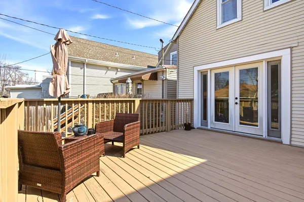 a view of a balcony with chairs and wooden floor