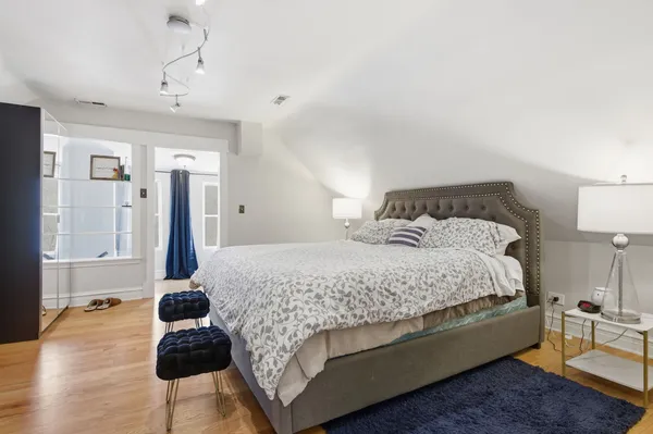 a bedroom with a bed wooden floor and lamp