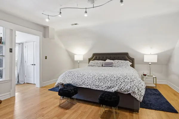 a bedroom with a bed and wooden floor