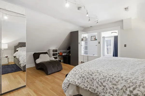 a spacious bedroom with a bed and a dresser