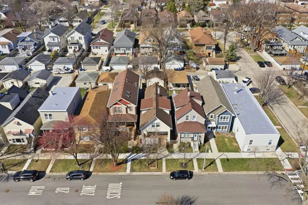 an aerial view of residential houses with outdoor space and parking