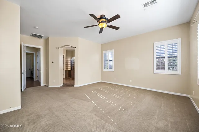 an empty room with fan and windows