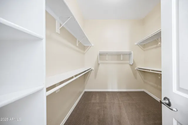 a view of walk in closet with empty racks