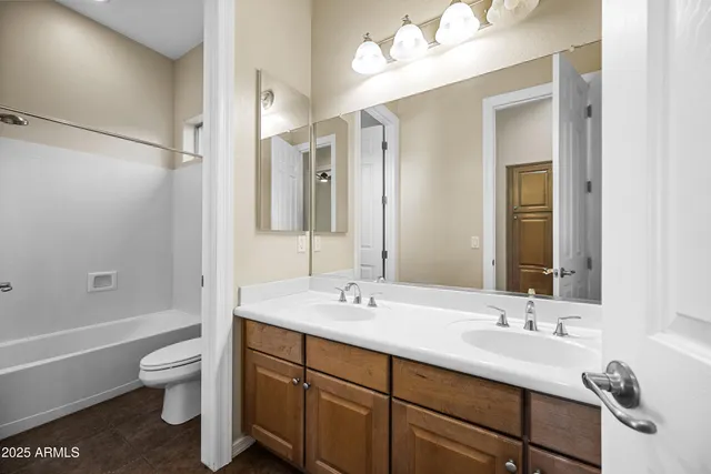 a bathroom with a toilet a sink a tub and a mirror