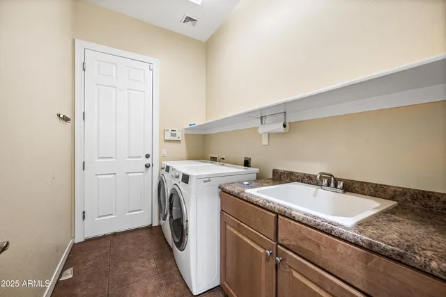 a utility room with sink dryer and washer