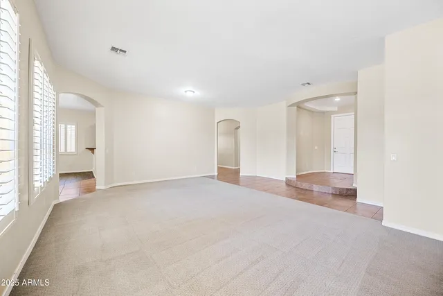 a view of empty room with wooden floor and window