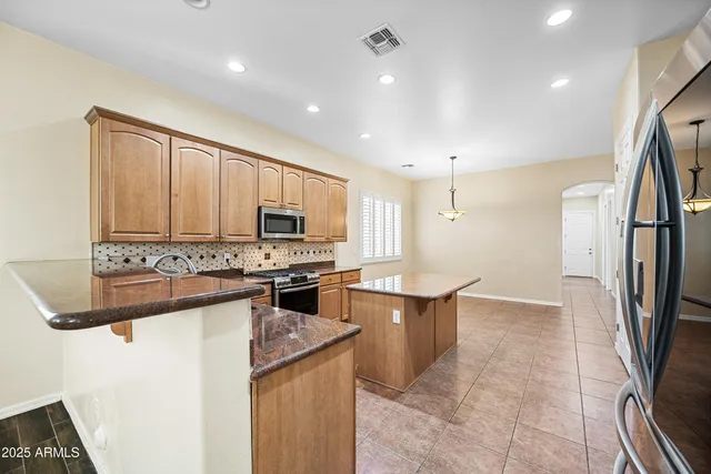 a kitchen with stainless steel appliances granite countertop a refrigerator a stove top oven a sink and dishwasher