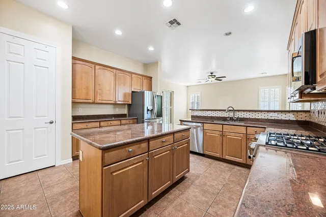 a kitchen with stainless steel appliances granite countertop a stove a sink and a refrigerator
