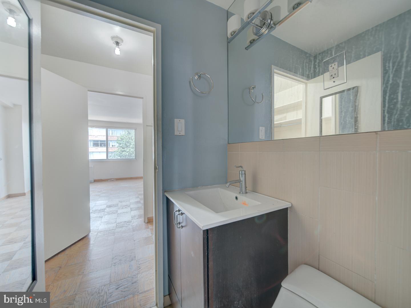 2829 Connecticut Avenue Northwest, Unit 606 Washington, DC 20008 - Photo 20 of 28 a bathroom with a sink mirror and a toilet