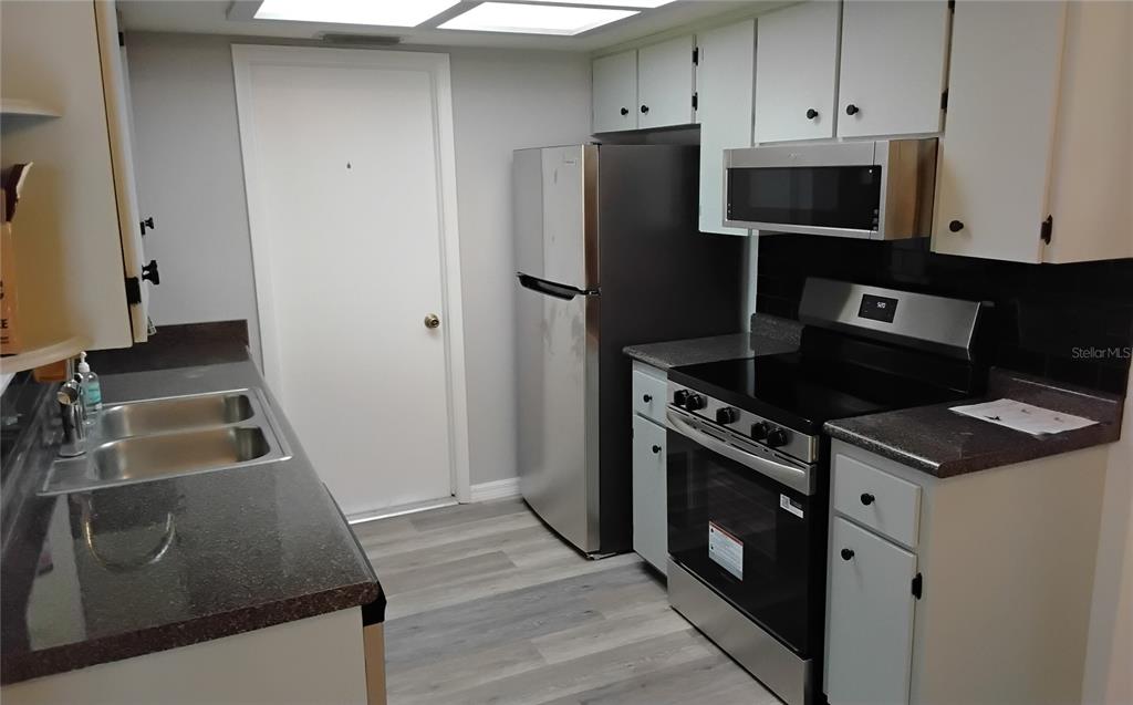 8328 Southwest 106th Place Ocala, FL 34481 - Photo 15 of 23 a kitchen with granite countertop a refrigerator stove and microwave