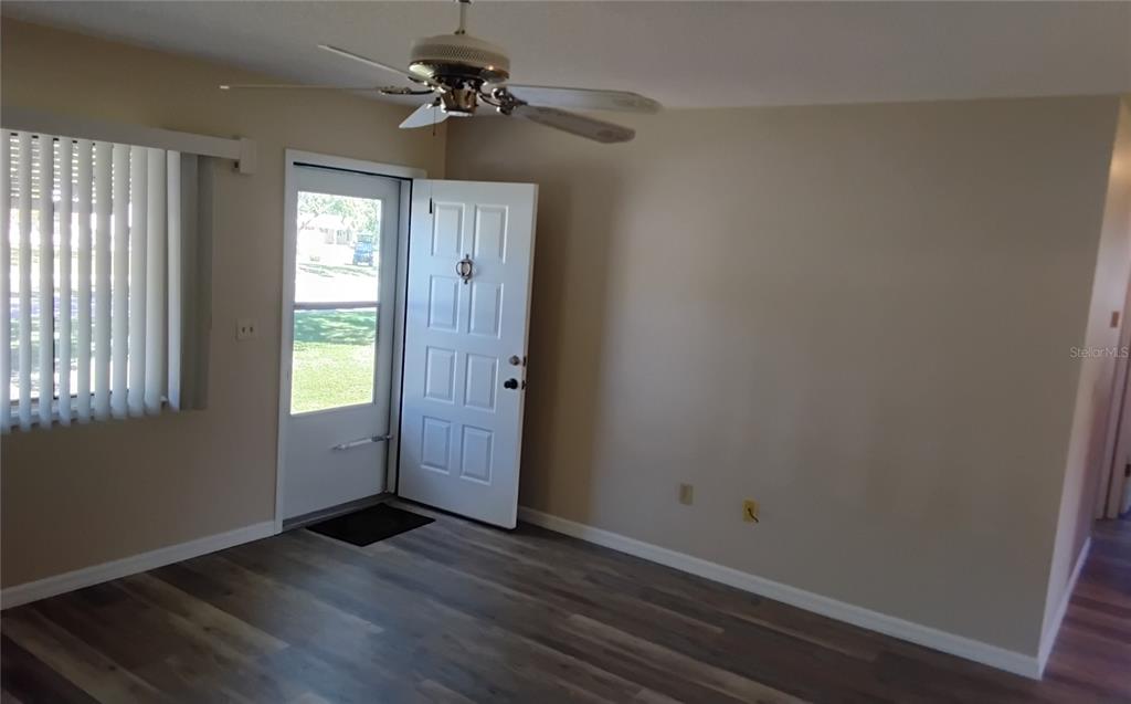 8328 Southwest 106th Place Ocala, FL 34481 - Photo 9 of 23 an empty room with wooden floor fan and windows